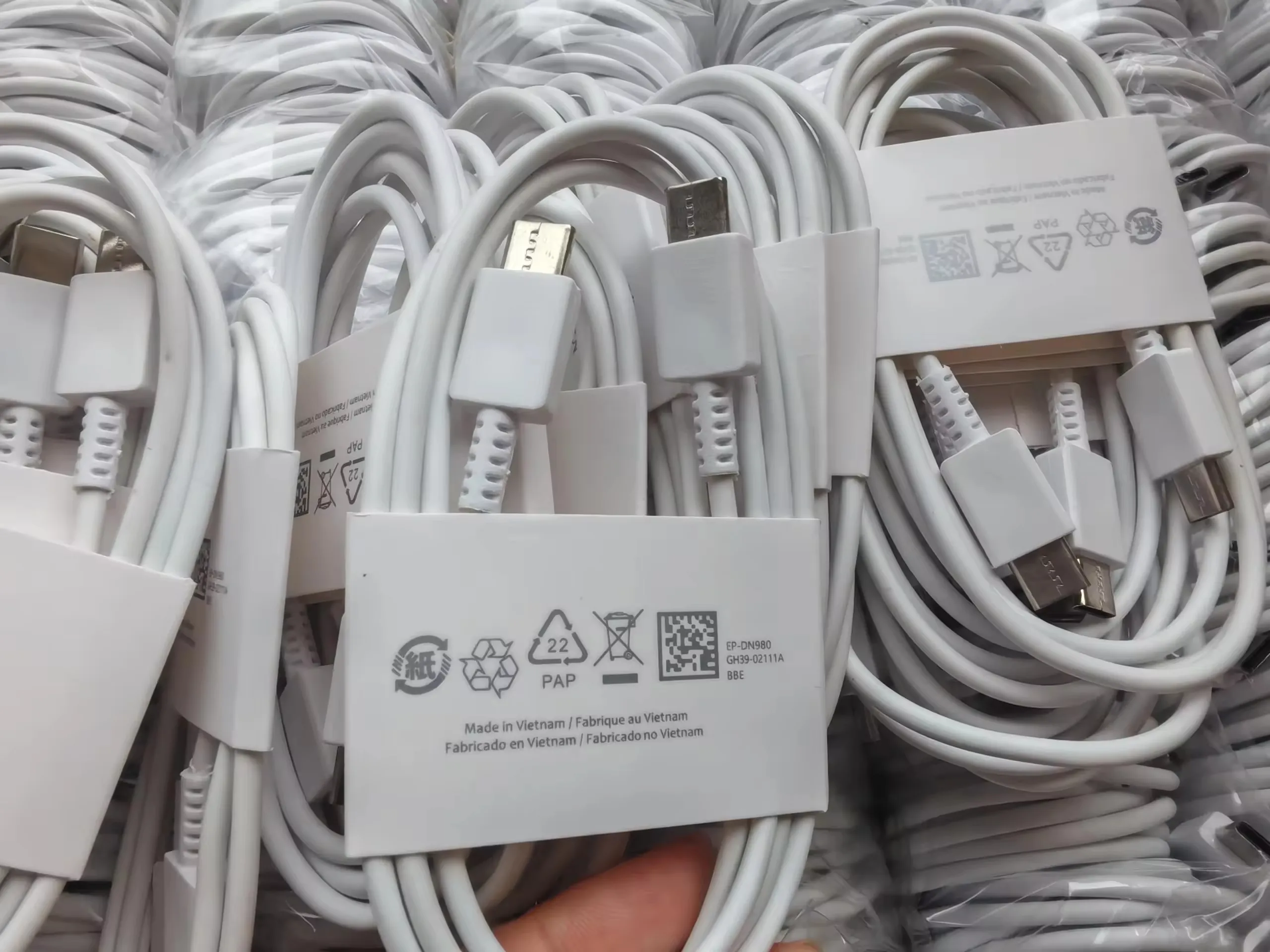 White Type-C to Type-C charging cables packed in bulk with paper sleeves and clear bags
