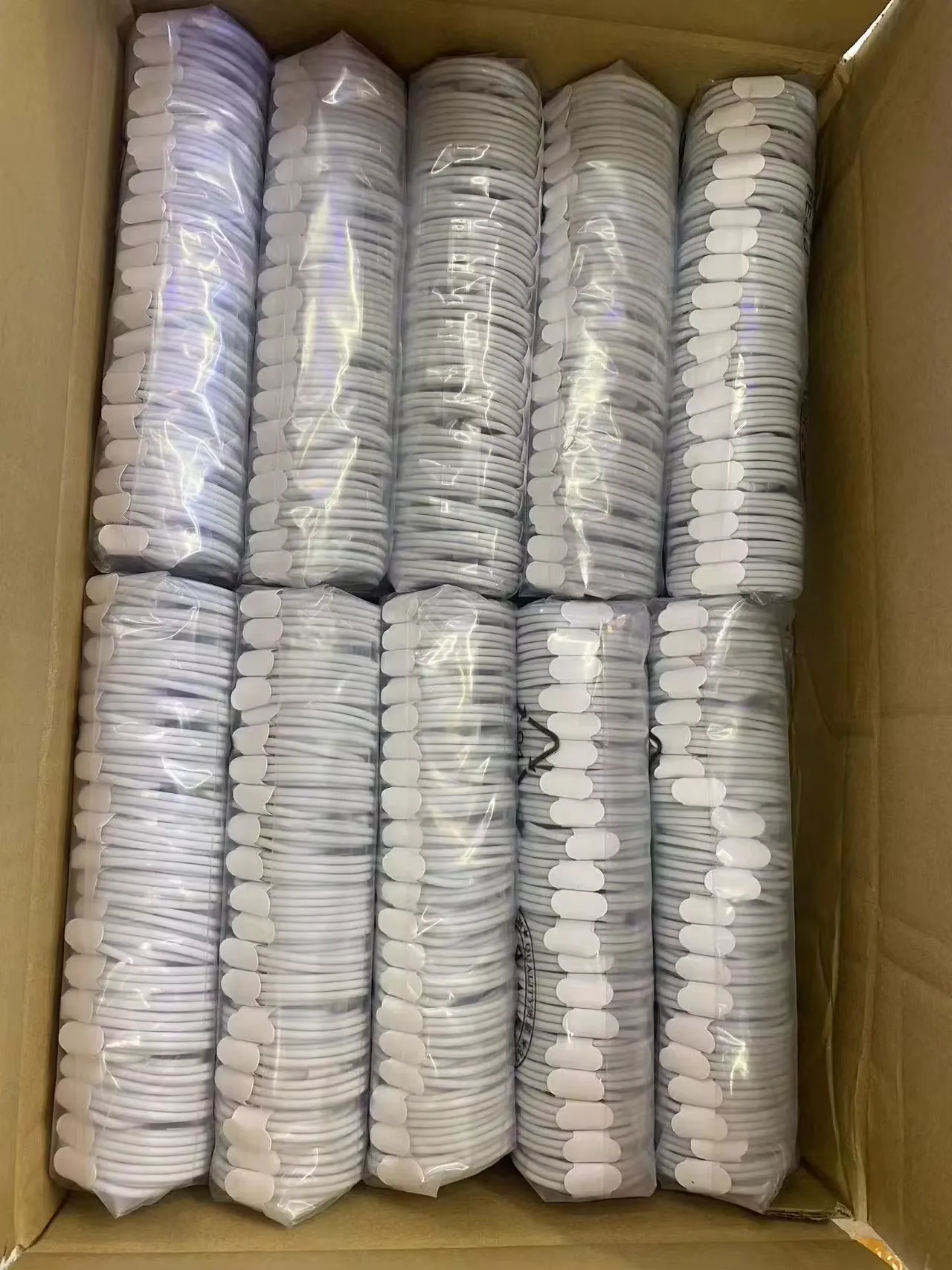 Bulk carton of bundled white charging cables