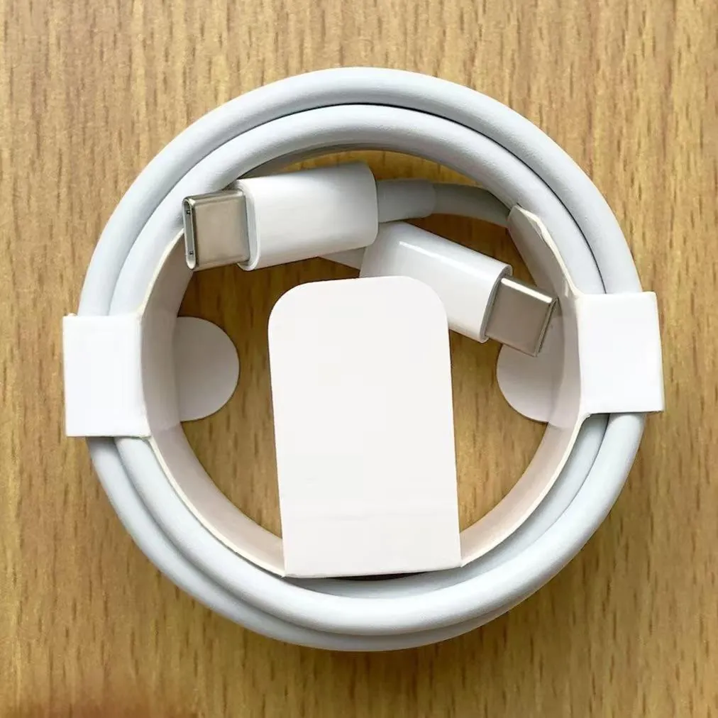 White dual Type-C fast charging cable coiled in a simple retail holder on a wood surface